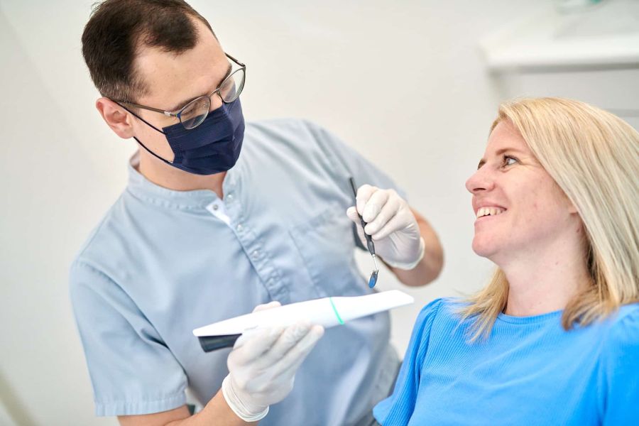 Dr. Carsten Kronauer bei der Behandlung einer Patientin mit dem Intraoralscanner, um digitale Aufnahmen des Gebiss anzufertigen.