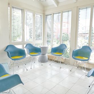 Wartezimmer der Zahnarztpraxis Bodensee Dental - Praxis Dr. Kronauer und Kollegen mit blauen Stühlen und gelben Sitzkissen.